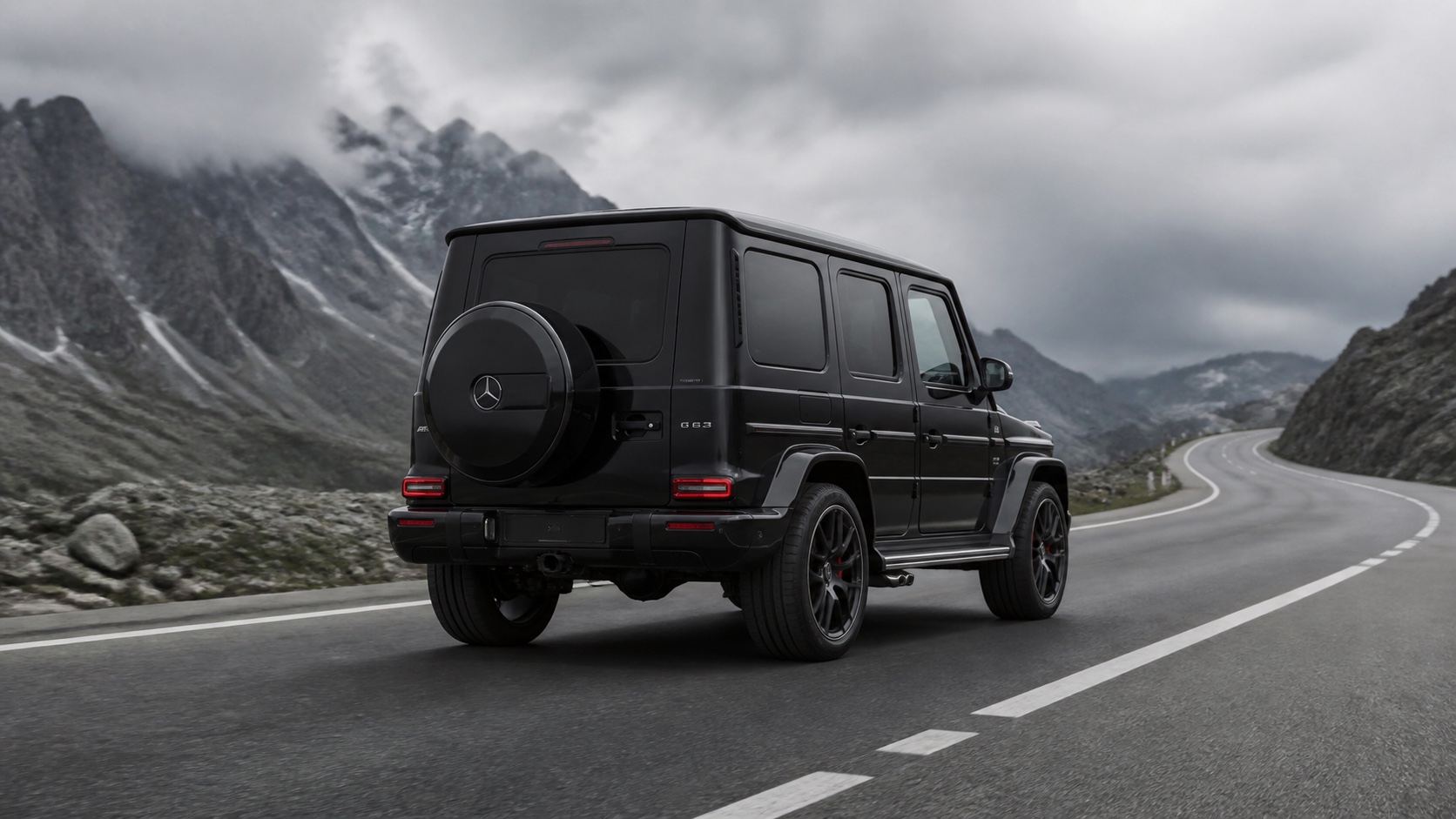 Mercedes-Benz G63 на горном серпантине, задний ракурс с запасным колесом