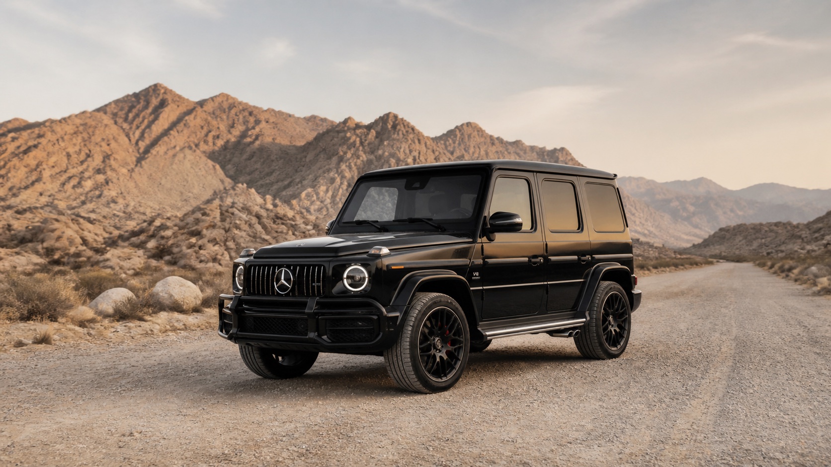 Mercedes-Benz G63 на дороге в пустыне, полный кузов на фоне скал